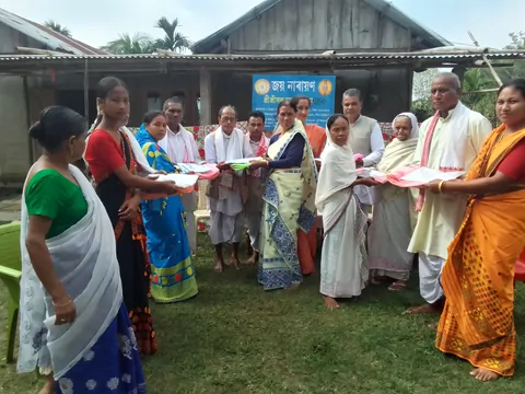 Members of SRI SRI SANTA SAMAJ distributing cloth to village women