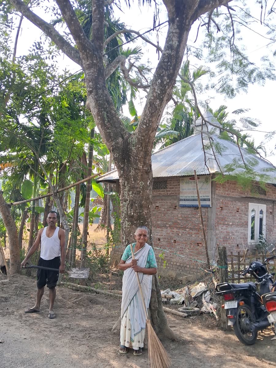 Villagers with a broom and hoe outside the registered office of SRI SRI SANTA SAMAJ