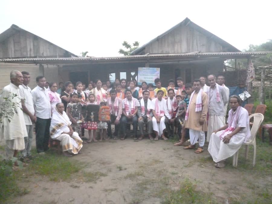 Members and villagers gathered together outside a village home